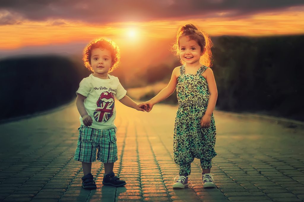 siblings - a little boy and little girl holding hands